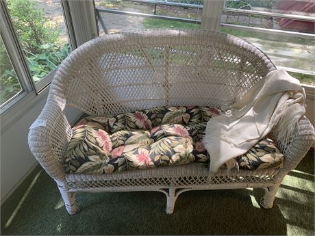 White Wicker Love Seat With Seat Pad and White Throw Blanket